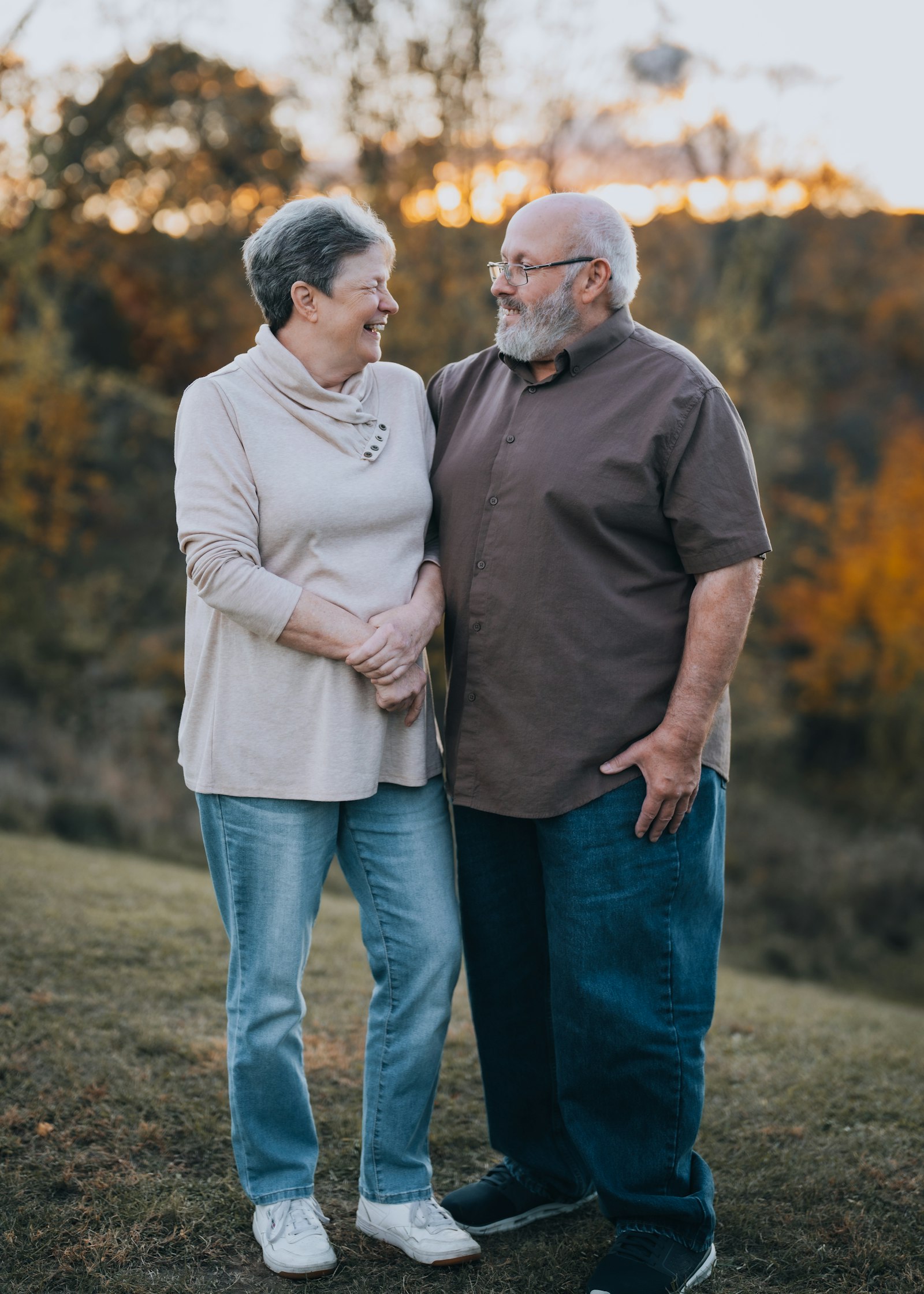 An older couple walking ranchland at sunset